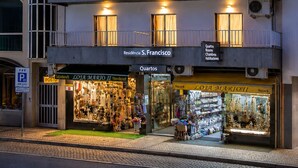 A multi-story building with balconies, a ground-floor shop, and a sign indicating 'Residência S. Francisco.' - Residencial Sao Francisco (Horta)