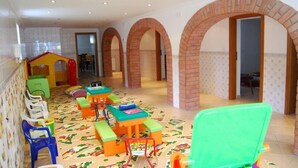 Una sala de juegos infantil con mobiliario colorido y piso estampado.