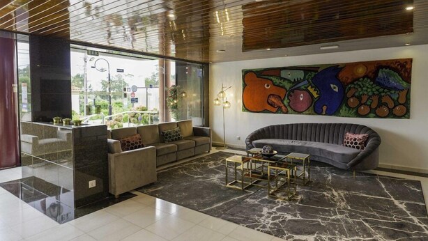 Una sala de estar moderna con un sofá, una mesa de centro y un cuadro abstracto grande en la pared.