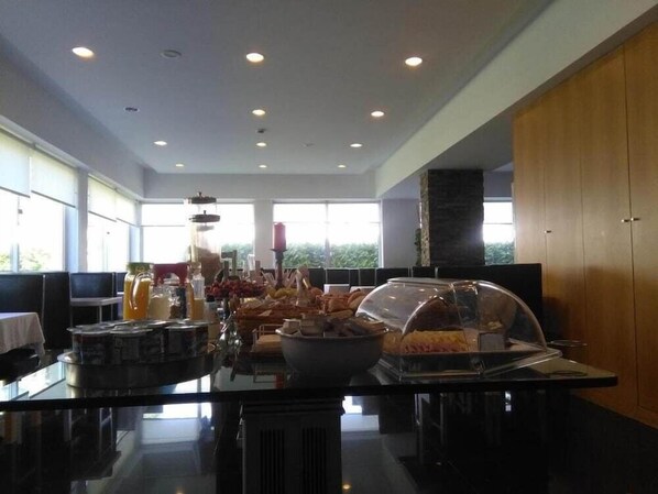 Ein Bereich mit Buffet und verschiedenen Speisen sowie einer Kaffeestation.