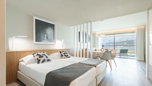 Une chambre d’hôtel moderne avec deux lits, un bureau et une vue sur la mer.