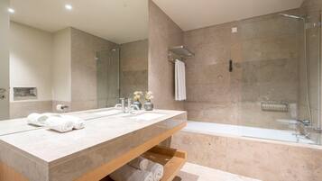 Un baño moderno con un espejo grande, dos lavamanos, una ducha y un estante de madera con toallas.