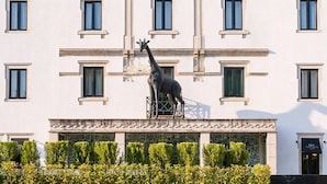 A building with multiple windows and a giraffe statue on the facade. - Grande Hotel Lisboa (Sao Pedro do Sul)