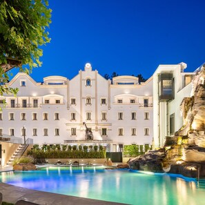 A hotel with a large pool, a fountain, and a building with multiple windows and balconies. - Grande Hotel Lisboa (Sao Pedro do Sul)
