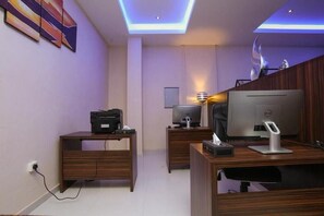 Un ufficio moderno con una scrivania, una stampante, un computer e una lampada.