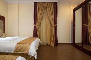Una camera d'albergo con un letto, uno specchio e tende.