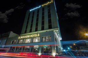 A hotel building with illuminated signage for Al Muhaiidib Hotels. - Almuhaidb Residence Garnata (Riyadh)