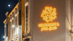Das äußere Erscheinungsbild des Gulanar Hotels mit einer auffälligen, beleuchteten Signatur.