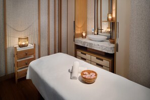 A hotel room with a bed, a wooden nightstand, a mirror, a marble sink, and a wooden bowl with flowers. - Crowne Plaza Jeddah Al Salam (Jeddah)