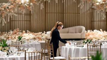 Un montaje formal para el comedor con mesas, sillas y un fondo floral.