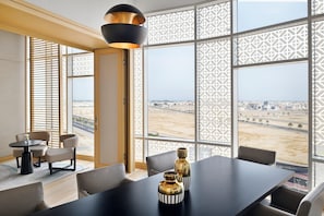 A modern dining area with a large table, chairs, and decorative vases.