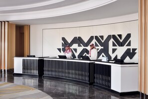 A reception desk with a modern design, featuring a geometric wall pattern and a sleek, curved counter. - Crowne Plaza Jeddah Al Salam (Jeddah)