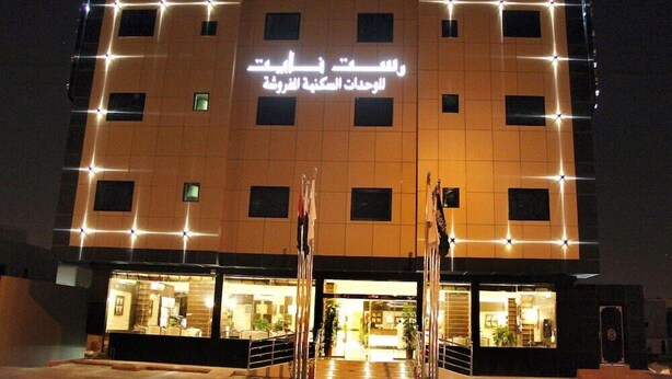 A hotel with a modern facade, multiple windows, and a sign in Arabic. - Rest Night Serviced Apartments - AL Nafal (Riyadh)