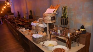 A buffet setup with various food items, baskets, and a hot food station. - Reef Home Luxury Hotel (Riyadh)