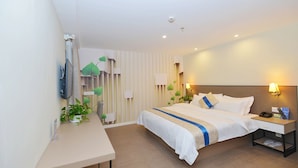 Habitación de hotel con cama, mesitas de noche, escritorio y televisor montado en la pared.