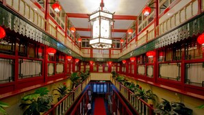A traditional building with a central corridor, red railings, and a hanging lantern. - Qianmen Courtyard Hotel (Beijing)
