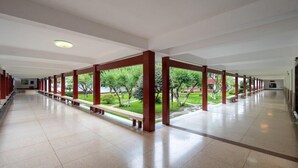 A long corridor with red pillars and benches, leading to an outdoor area with trees and a lawn. - Pipaxi Hunan Zhangjiajie (Zhangjiajie)