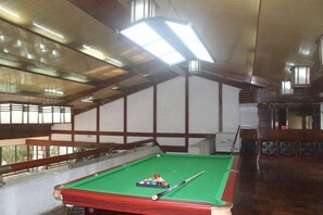 A pool table with balls and a cue stick in a room with wooden beams and a balcony. - Pipaxi Hunan Zhangjiajie (Zhangjiajie)