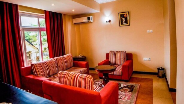 A living room with red sofas, a small round table, and a patterned rug.