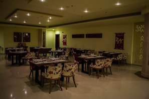 A restaurant with multiple dining tables and chairs, arranged in a spacious layout. - Tolip Taba Resort And Spa (Taba Heights)