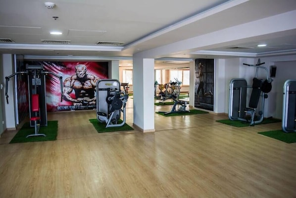 A gym with various exercise equipment, including a squat rack and weight benches. - Tolip Taba Resort And Spa (Taba Heights)