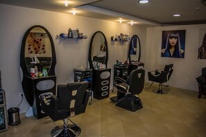 A salon with multiple mirrors, chairs, and shelves with hair products. - Tolip Taba Resort And Spa (Taba Heights)
