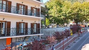 A multi-story hotel with balconies, a stone facade, and a view of a mountain. - City Hotel Apollonion (Karpenisi)
