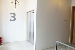 A hallway with a number '3' on the wall, a fire extinguisher, and a door with a number '302-308' above it. - Icelandic Apartments (Kópavogur)