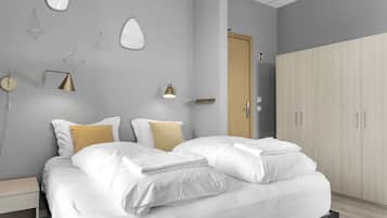 A modern bedroom with a bed, bedside tables, a wardrobe, and wall-mounted lamps.
