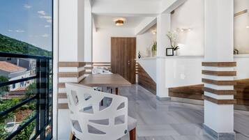 A modern interior with a dining area, a staircase, and a view of the outside.