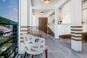 A modern interior with a dining area, a staircase, and a view of the outside. - Hotel Porat (Neum)
