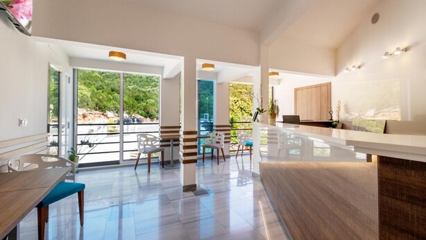 A spacious kitchen with a large island, modern appliances, and a view of greenery outside. - Hotel Porat (Neum)