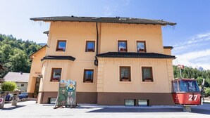 A two-story building with multiple windows and a sign that reads "BERG". - Apartment House Berghi Ii (Kranjska Gora)