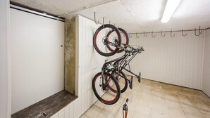 A room with two bicycles mounted on hooks, a bench, and a door. - Apartment House Berghi Ii (Kranjska Gora)