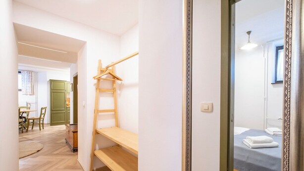 A bedroom with a bed, a wooden shelf, and a mirror with an ornate frame. - Apartment House Berghi Ii (Kranjska Gora)