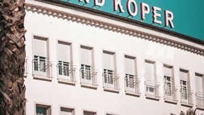 En byggnad med skylten ”GRAND KOPER” på fasaden.