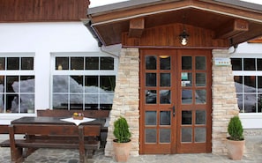 A hotel entrance with a stone facade, wooden door, and a sign indicating a 4-star rating. - Bohinj (Bohinj)