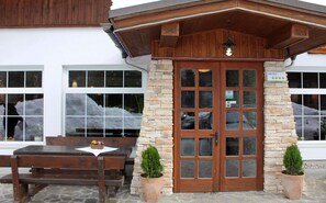 A hotel entrance with a stone facade, wooden door, and a sign indicating a 4-star rating. - Bohinj (Bohinj)