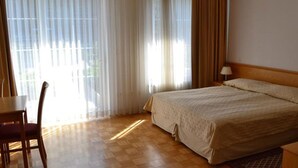 A hotel room with a bed, a desk, a chair, and a lamp. - Bohinj (Bohinj)