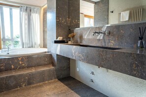 A bathroom with a bathtub, a large mirror, and a marble countertop. - Bohinj (Bohinj)