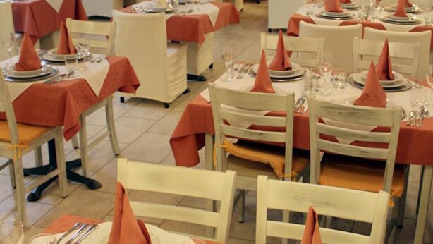 A dining area with tables set for service, chairs, and a tiled floor. - Bohinj (Bohinj)