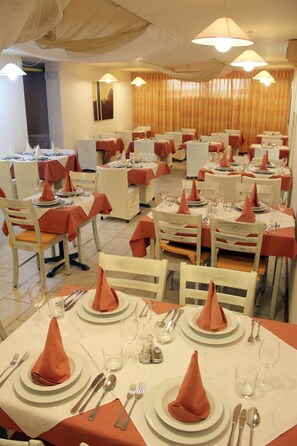 A dining area with tables set for multiple guests, each with a folded napkin, cutlery, and glasses. - Bohinj (Bohinj)