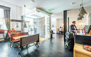A modern hotel lobby with a wooden bench, glass walls, and a visible exit sign. - Z Hotel Glasgow (Glasgow)