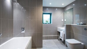 A modern bathroom with a bathtub, toilet, and sink.