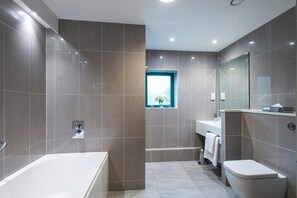 Une salle de bain moderne avec une baignoire, des toilettes et un lavabo.