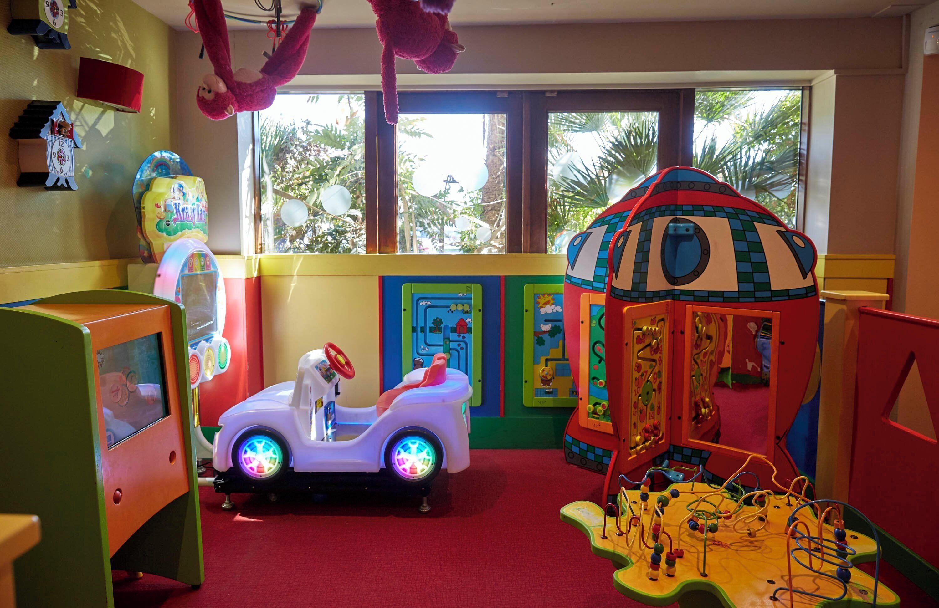 A children's play area with a ride-on toy, a playhouse, and a climbing structure.