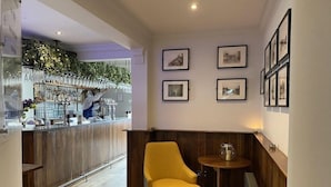 A bar area with a counter, a yellow armchair, and framed pictures on the wall. - Craigiebield House Hotel (Penicuik)