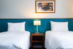 A hotel room with two beds, a teal headboard, a nightstand with a lamp, and a framed picture on the wall. - Best Western Middlesbrough (Middlesbrough)
