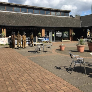 A building with a bar and grill, outdoor seating, and a sign for M&S Simply Food. - Ibis Budget Warrington Lymm Services (Lymm)