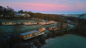 A cluster of modern cabins with a view of the water and trees. - The Mole Resort (Umberleigh)